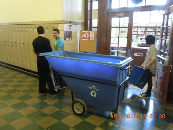 High school students use bins and carts to collect items for recycling from around the school.