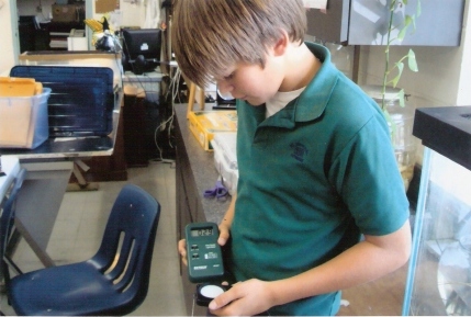 Student at St. Michael Lutheran school in Florida uses a light meter to record lighting levels in the school