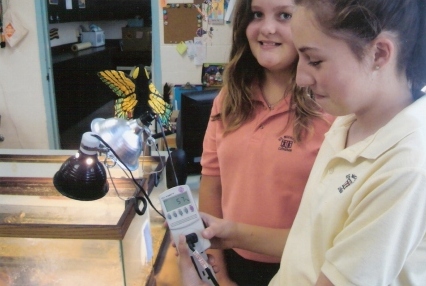 Students at St. Michael Lutheran school use a watt meter to record energy usage