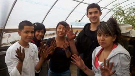 Five Latino students show their dirty hands from a vermicomposting project at the Urban Farm in Denver
