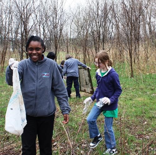 Two Rivers Middle School students clean up waste on campus.