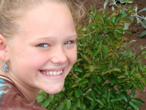 fifth-grader-smiles-after-planting-school-butterfly-garden