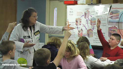 teacher-in-lab-coat-with-class