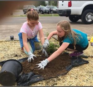 two-girls-gather-soil-for-planting