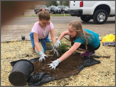 two-girls-gather-soil-for-planting