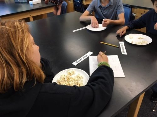Students representing different generations eating popcorn