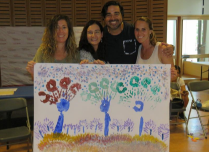 Educators in front of a finger painting of trees