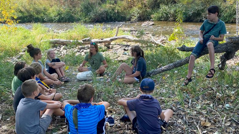 Children sit in a circle during a Project Learning Tree outdoor classroom activity.