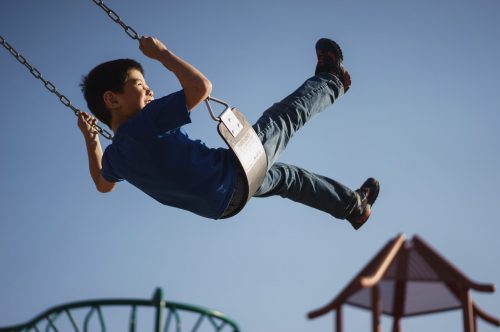 young-boy-swinging-on-swingset