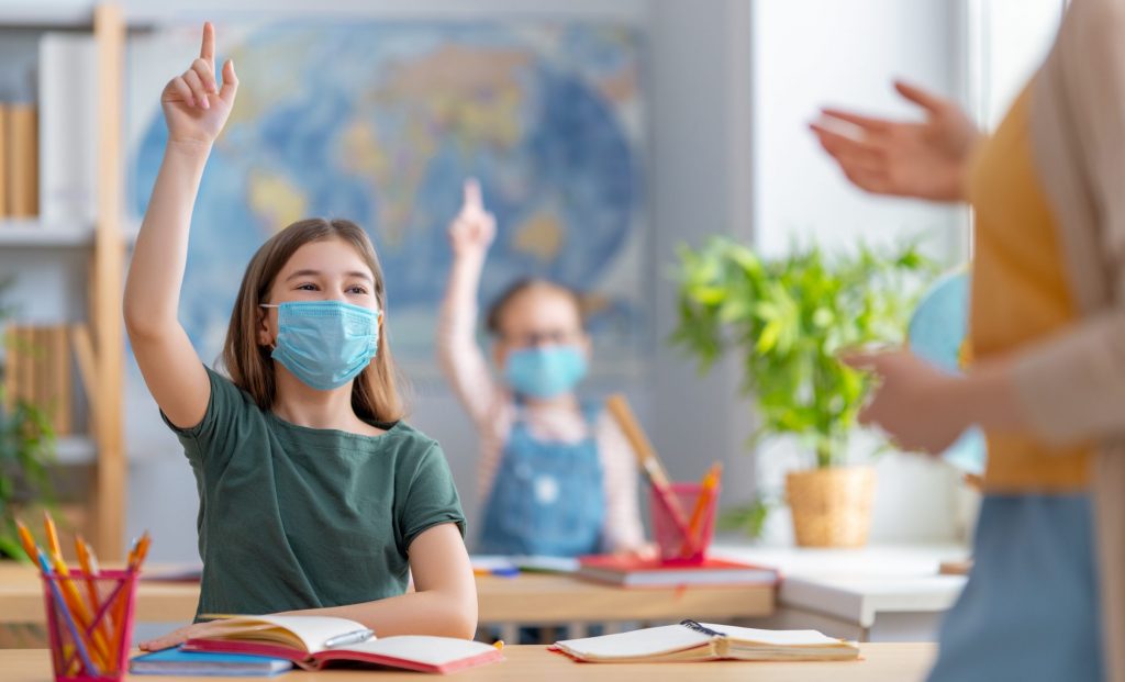 Kids wearing facemasks learning in class