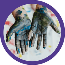 child hands with blue paint on their palms