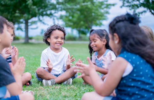 group of kids sitting in a circle clapping