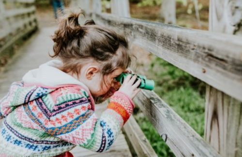 Little girl looking through binoculars