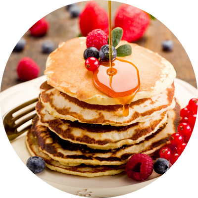 stack of pancakes with maple syrup and fresh strawberries