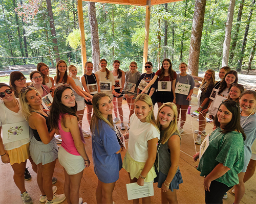 A photograph depicting a group of educators participating and learning an interactive nature-based activity created for children, available in curriculum developed by Project Learning Tree, PLT.